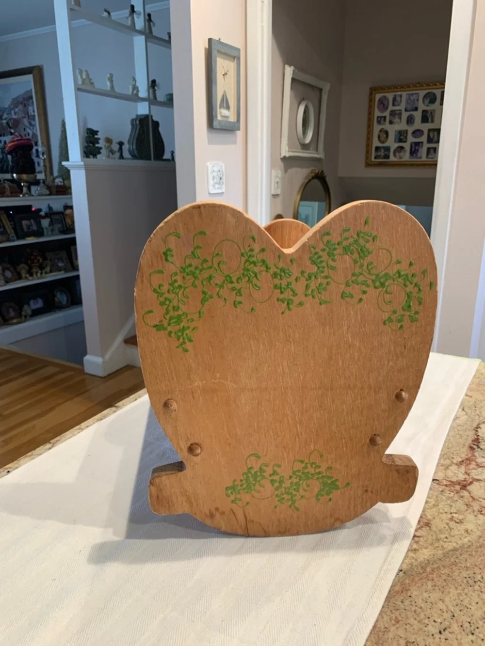 Vintage wooden doll cradle heart-shaped design painted with floral details.